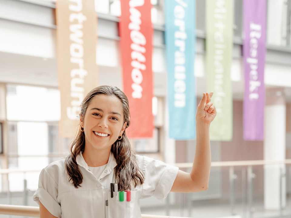 Ausbildung Pflegekraft_im_Atrium_zeigt_nach_oben.jpg